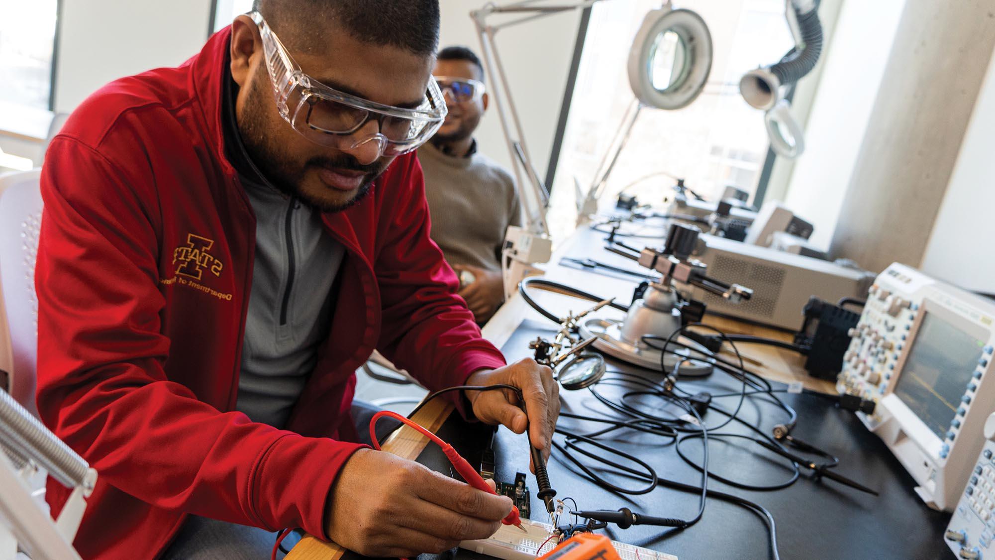 两个学生在焊接实验室研究电子产品.