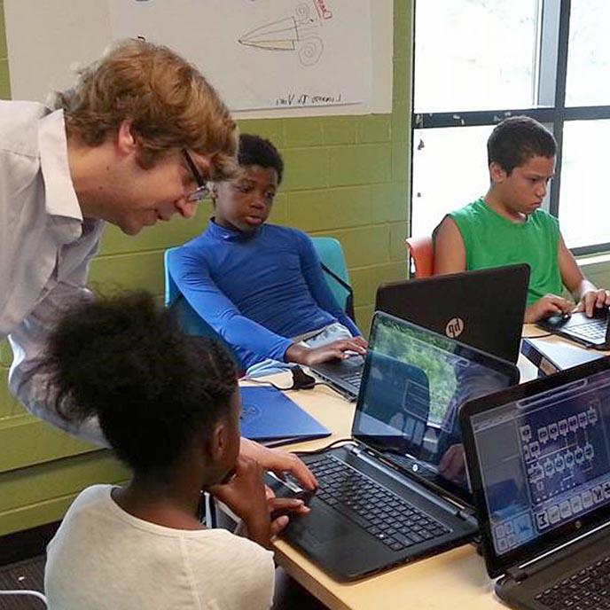 克里斯托弗·惠特在教室里和孩子们一起研究基于游戏的STEM工具