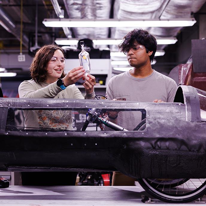 两名学生在机械工程车辆上工作