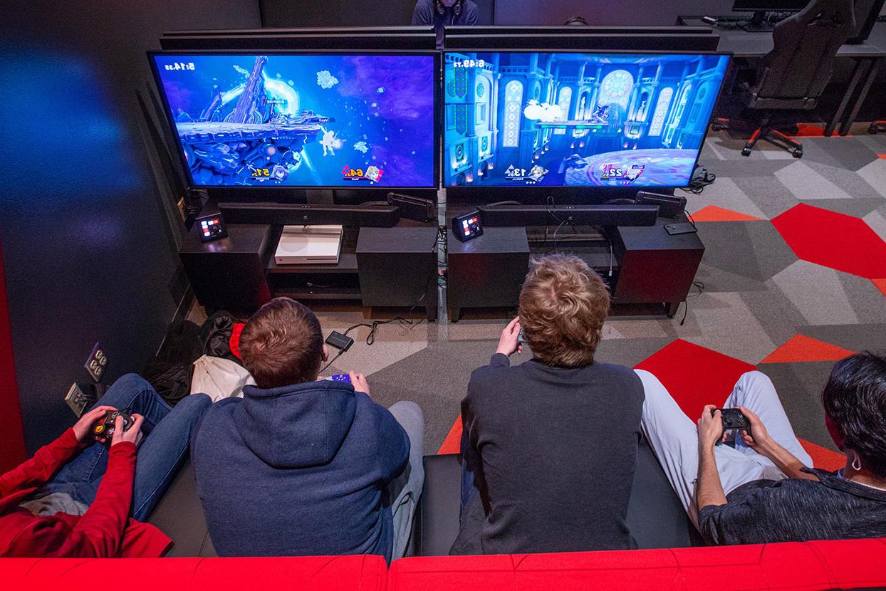 四个学生在娱乐服务电子竞技室玩电子游戏