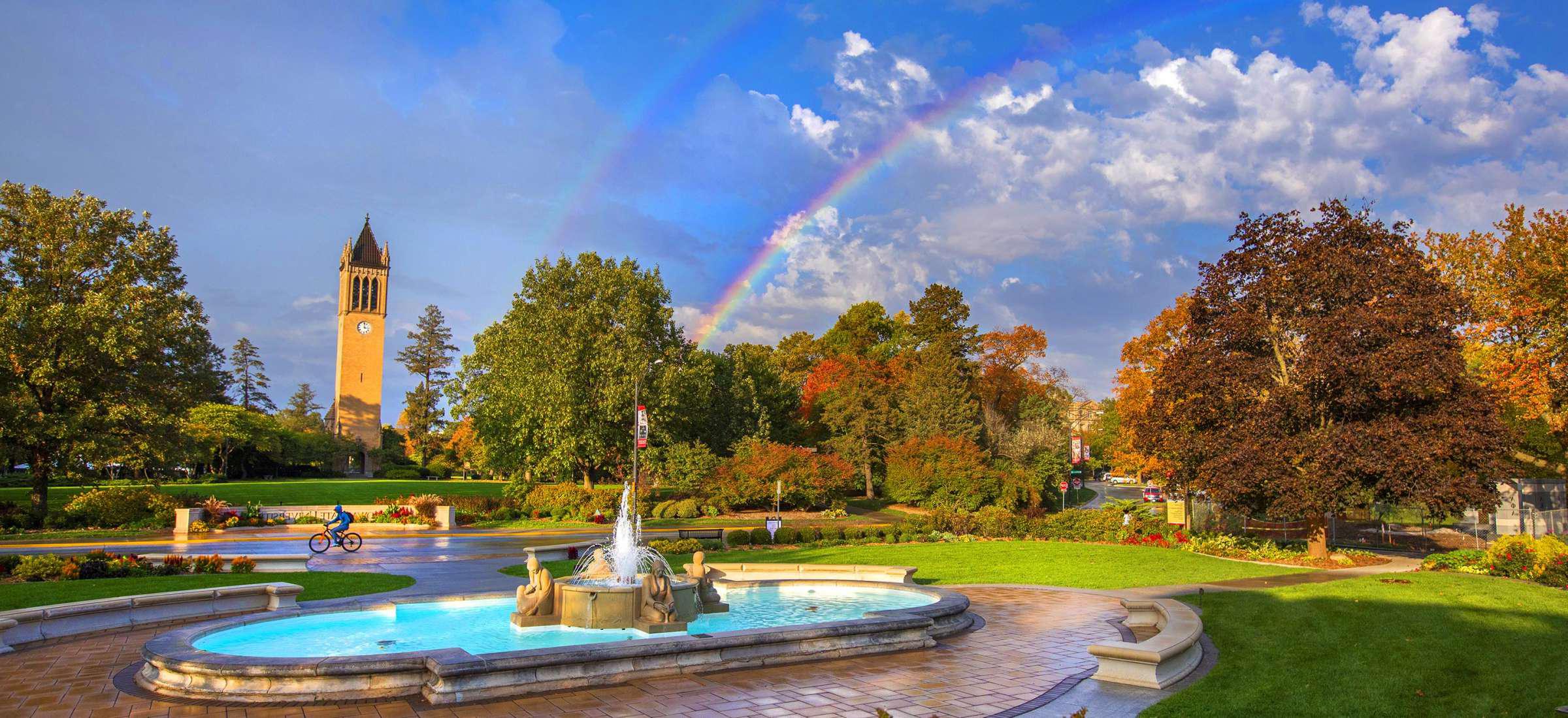 喷泉和钟楼的观点与双彩虹背景